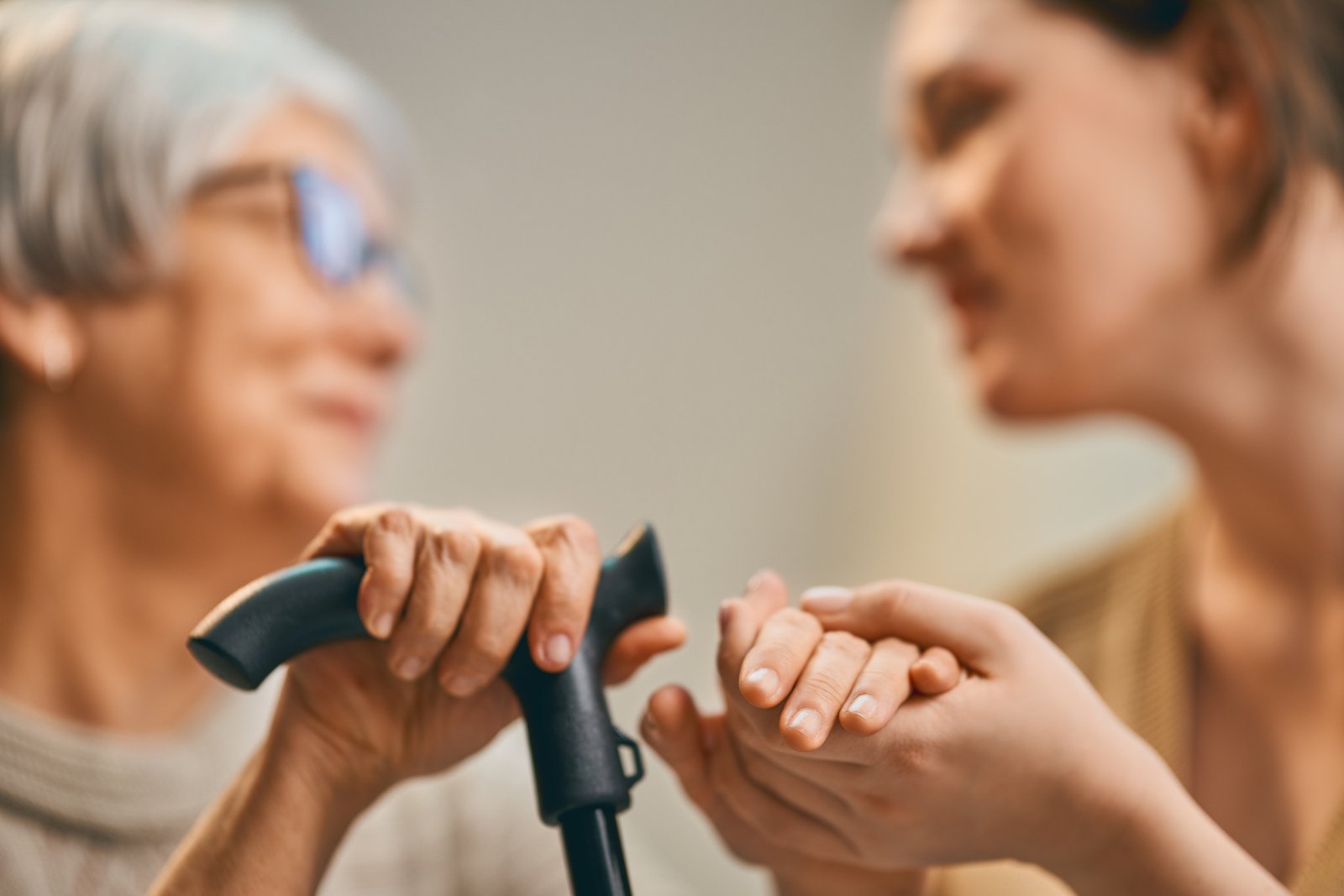 A caregiver holding the hand of an elderly client